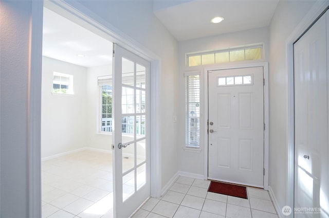 entryway with light tile patterned floors, baseboards, and french doors