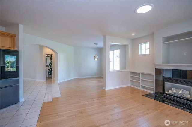 4329 Fairwood Blvd NE, Tacoma, WA 98422 - living area featuring light wood-style flooring, recessed lighting, arched walkways, baseboards, and a tile fireplace