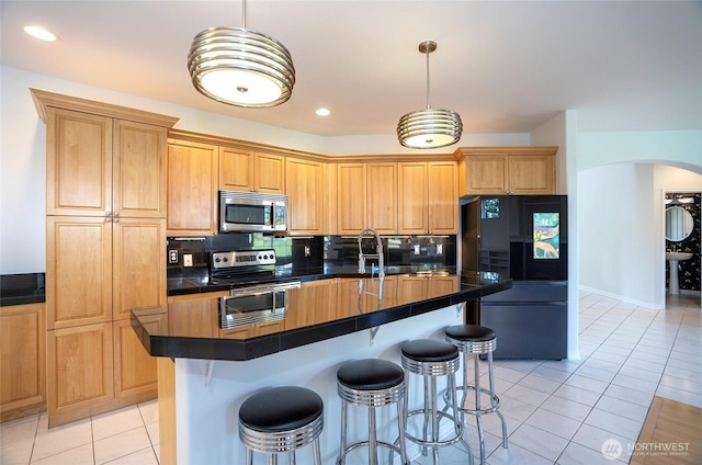 4329 Fairwood Blvd NE, Tacoma, WA 98422 - kitchen with dark countertops, tasteful backsplash, stainless steel appliances, arched walkways, and light tile patterned flooring