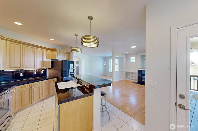 4329 Fairwood Blvd NE, Tacoma, WA 98422 - kitchen with light brown cabinets, stainless steel range with electric stovetop, arched walkways, light tile patterned flooring, and a sink
