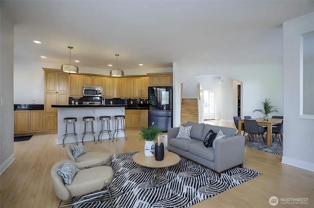 4329 Fairwood Blvd NE, Tacoma, WA 98422 - living room featuring arched walkways, recessed lighting, light wood finished floors, and baseboards