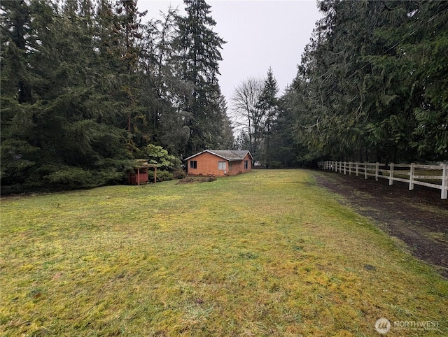 view of yard with fence and a rural view