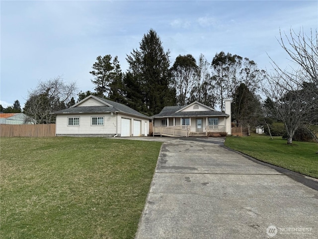 view of front facade featuring a chimney, a porch, a front yard, fence, and a garage