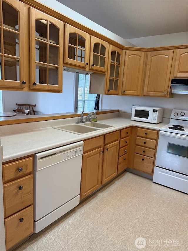 kitchen with white appliances, glass insert cabinets, light floors, and a sink