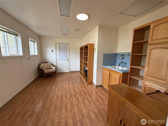 interior space with a sink, light wood-style flooring, and baseboards