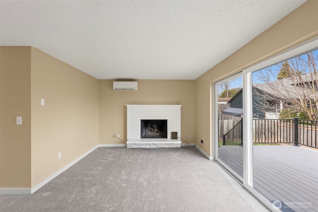 unfurnished living room featuring carpet, baseboards, a fireplace with raised hearth, a wall mounted air conditioner, and a textured ceiling