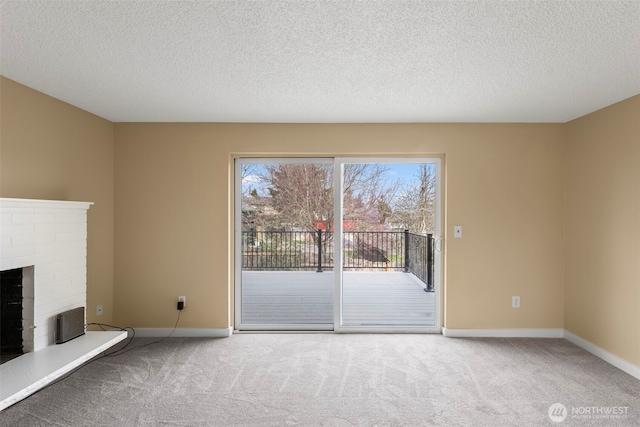 unfurnished living room featuring a brick fireplace, carpet flooring, and baseboards