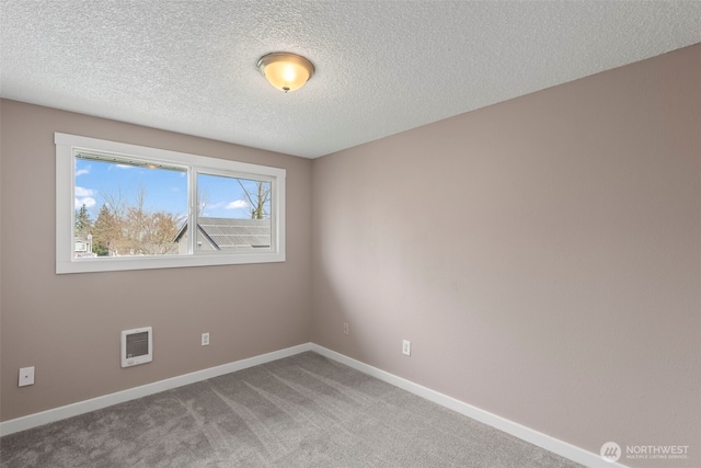 unfurnished room with baseboards, a textured ceiling, and carpet flooring