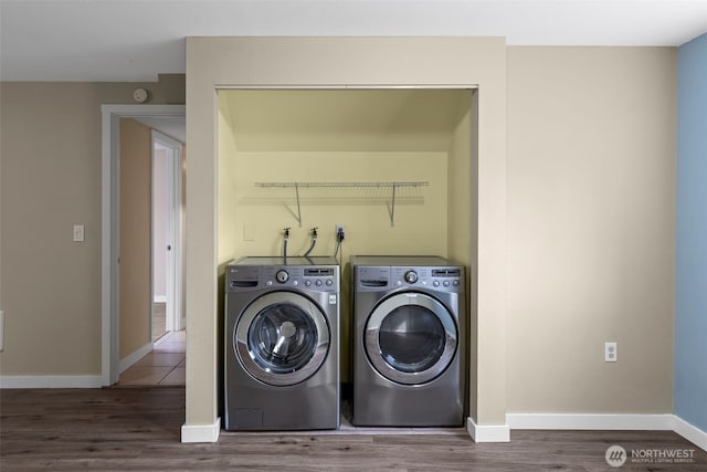 laundry room with washer and clothes dryer, laundry area, baseboards, and wood finished floors