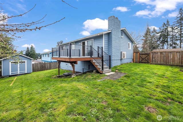 back of property with an outdoor structure, a fenced backyard, a lawn, and a shed