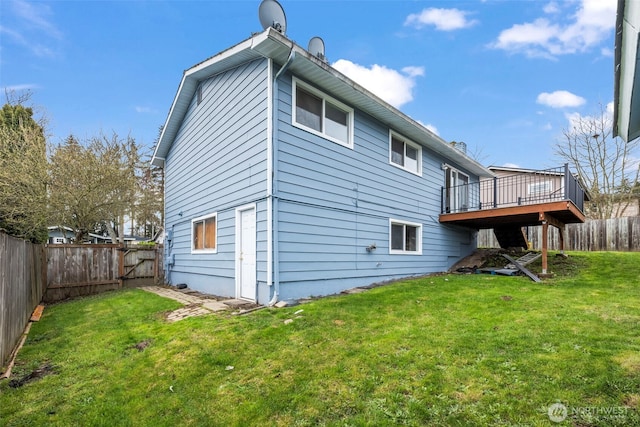 back of property featuring a yard, a deck, and a fenced backyard