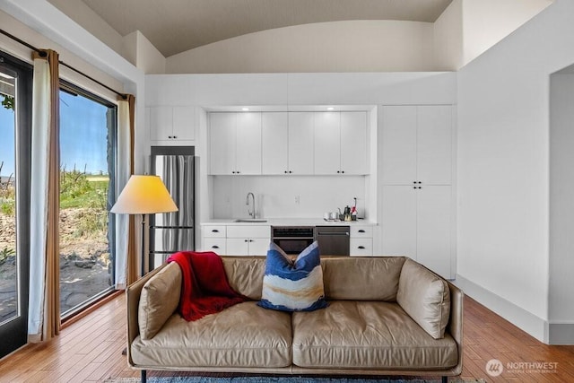 344 Silica Rd NW Unit 8, Quincy, WA 98848 - living area featuring bar with sink, light wood-style floors, and vaulted ceiling