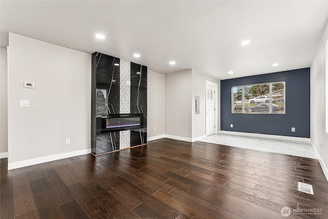 unfurnished living room with baseboards, visible vents, wood finished floors, and recessed lighting