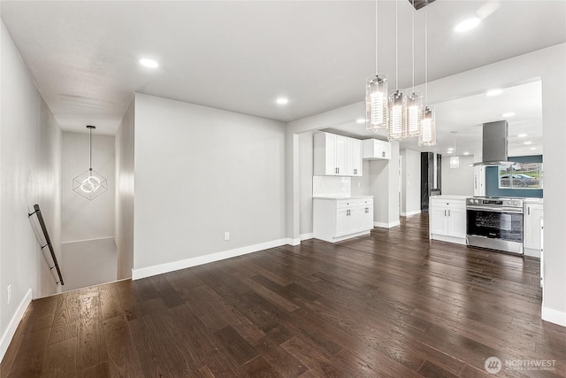 unfurnished living room with recessed lighting, dark wood finished floors, and baseboards