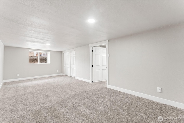 interior space with a textured ceiling, baseboards, and carpet flooring