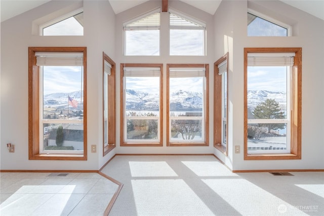 interior space featuring a healthy amount of sunlight, vaulted ceiling, and visible vents