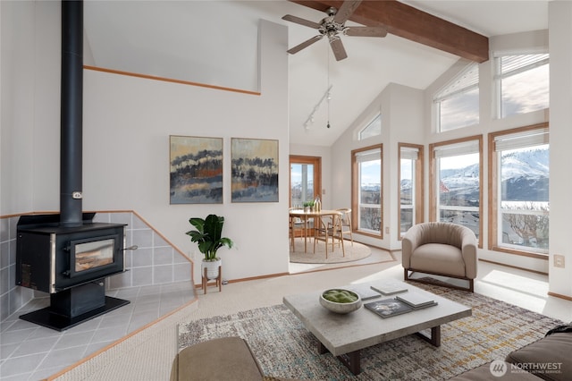 living room featuring high vaulted ceiling, beamed ceiling, plenty of natural light, and a wood stove