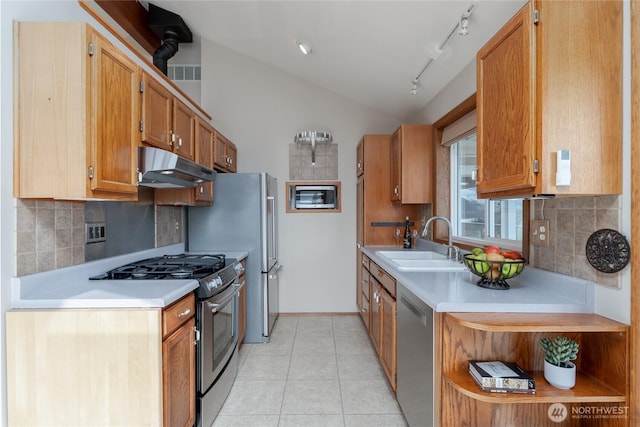 kitchen with light tile patterned floors, lofted ceiling, under cabinet range hood, stainless steel appliances, and a sink