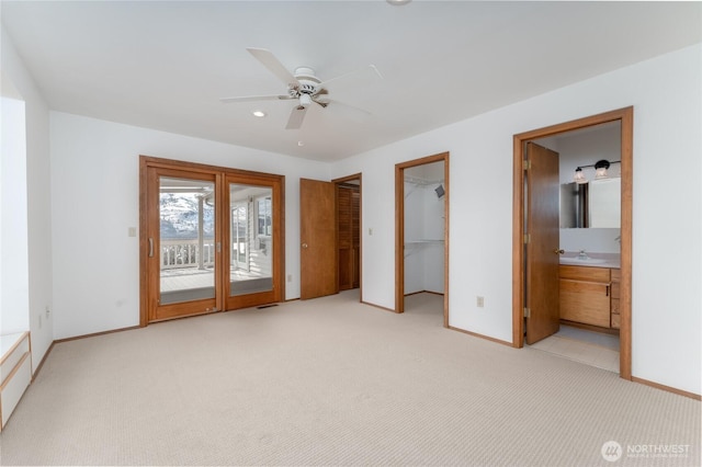 unfurnished bedroom with light carpet, baseboards, connected bathroom, access to outside, and a sink