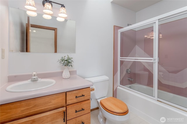 full bath featuring tile patterned flooring, vanity, toilet, and bath / shower combo with glass door