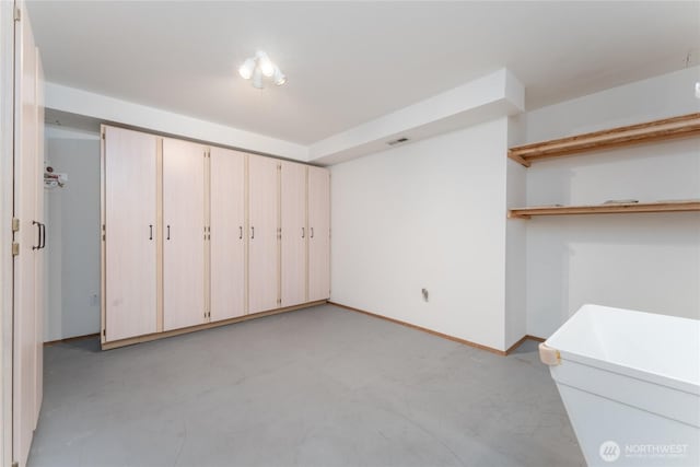 unfurnished bedroom with concrete flooring, visible vents, and baseboards