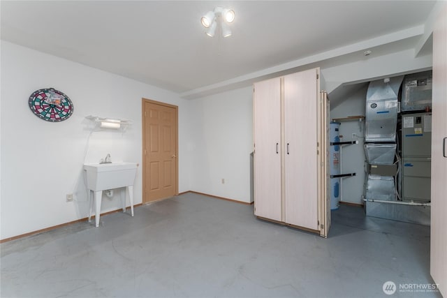 unfurnished bedroom with water heater, concrete floors, and baseboards