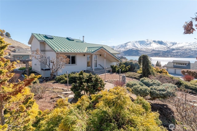 view of front of property with metal roof, a standing seam roof, and a mountain view