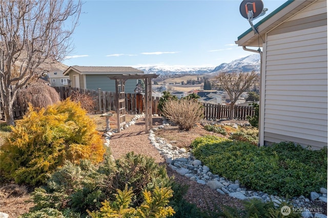 view of yard featuring fence and a mountain view