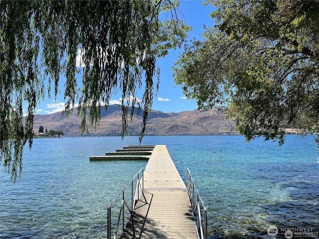 view of dock with a water and mountain view