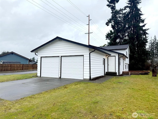 garage featuring fence and driveway