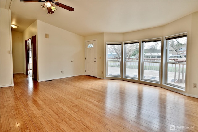 unfurnished living room with baseboards, a ceiling fan, and light wood finished floors