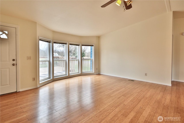 empty room with baseboards, light wood-style floors, and a ceiling fan