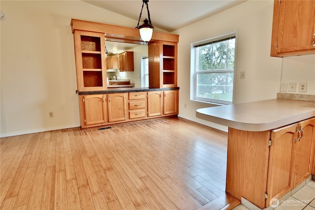 kitchen with open shelves, a peninsula, light wood finished floors, and vaulted ceiling