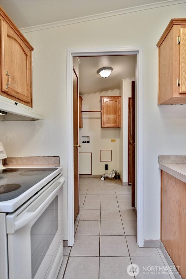 kitchen featuring ornamental molding, white electric range, under cabinet range hood, light tile patterned flooring, and light countertops