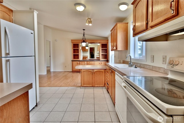 kitchen with pendant lighting, vaulted ceiling, light tile patterned floors, white appliances, and a sink