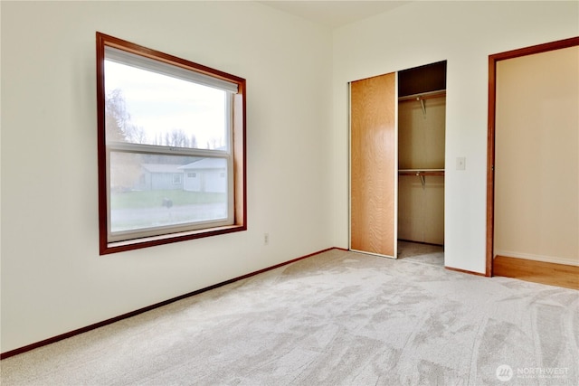 unfurnished bedroom featuring a closet, carpet floors, and baseboards