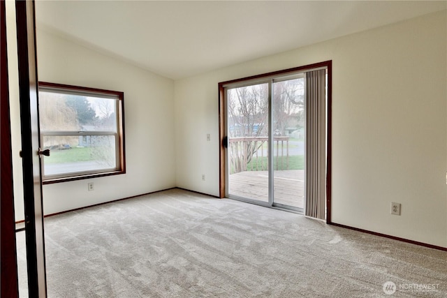 carpeted spare room with baseboards and vaulted ceiling