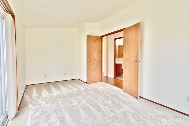 unfurnished bedroom with baseboards and light colored carpet