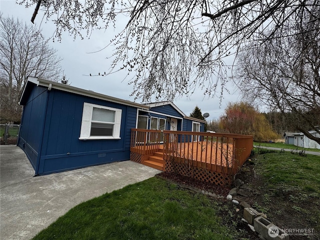 back of house featuring crawl space, a patio, a lawn, and a deck