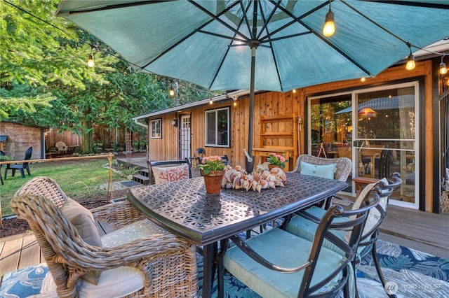 wooden terrace with outdoor dining space and fence