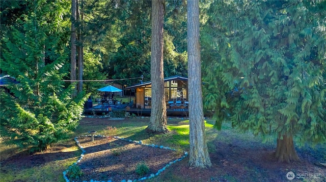 view of yard with a deck and a view of trees