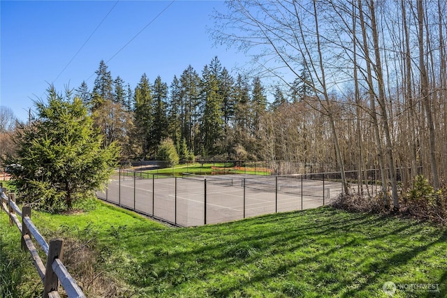 view of sport court featuring a yard and fence