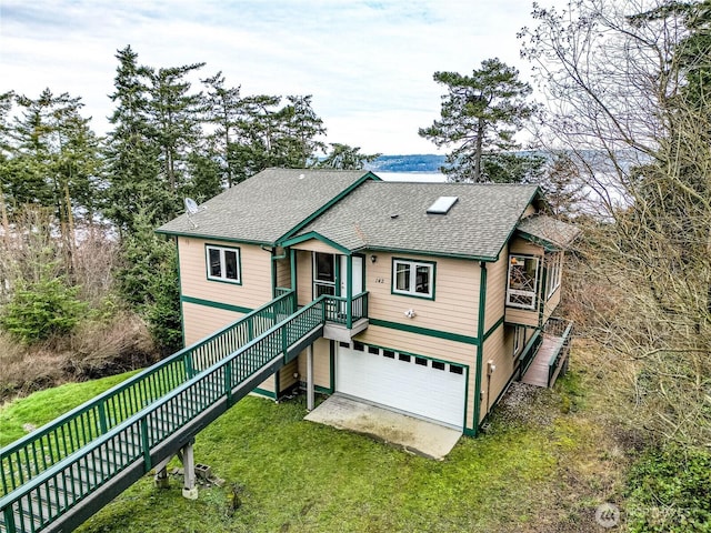 view of front of house with a garage, driveway, roof with shingles, and stairs