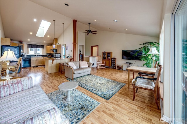 living area with a skylight, light wood finished floors, ceiling fan, high vaulted ceiling, and recessed lighting