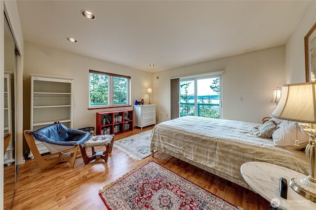 bedroom featuring access to outside, wood finished floors, and recessed lighting