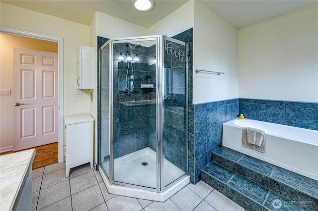 bathroom with a shower stall, a bath, and tile patterned floors