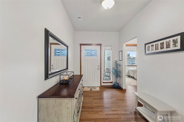 foyer entrance featuring visible vents and wood finished floors