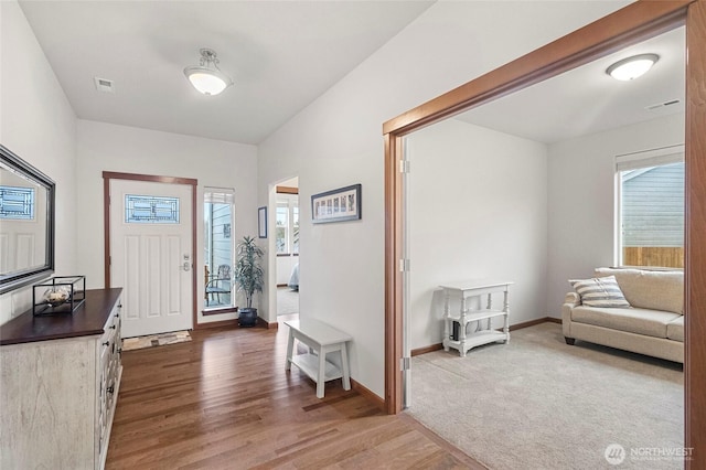 foyer entrance featuring dark wood finished floors, visible vents, plenty of natural light, and baseboards