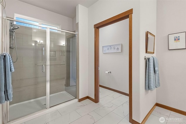 full bathroom featuring a stall shower, marble finish floor, and baseboards