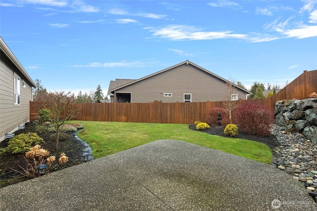 view of property exterior with a patio area, a fenced backyard, and a yard